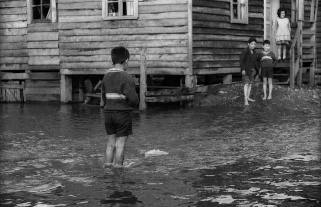 Fotografìa de niños descalsos sobre el agua, inundación en ciudad de la unión